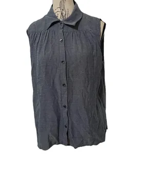 The Cabi Chambray Sleeveless Blouse in blue is a stylish and versatile top perfect for summer, fall, or spring. With a collared neckline, button closure, and ruffle accents, this high-low shirt features a cutout back for added interest. thumbnail 4