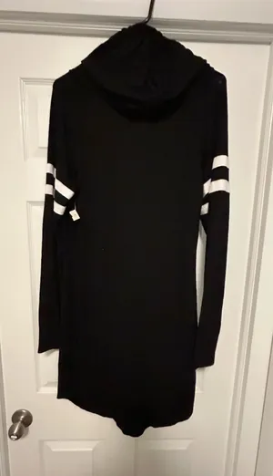 Casual hooded long-sleeve dress with sporty white stripe accents on the sleeves. Lightweight, soft fabric for comfortable everyday wear. Simple pull-on design with a relaxed, flattering fit. No Boundaries Black Hooded Long-Sleeve Dress dz XL White Sleeve Stripes new with size 15-17 thumbnail 1