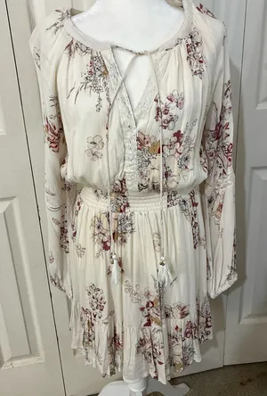 The American Rag Long Sleeve Lace Up Bodice Floral Dress in Cream is a stylish and versatile option for women. This fit & flare dress features a floral pattern in cream, pink, and white, making it perfect for various occasions such as travel, weddings, parties, or casual outings. The long sleeves and lace-up bodice add a touch of elegance, while the short dress length adds a trendy flair. Made from a blend of rayon, cotton, polyester, and linen, this dress offers both comfort and style for women in size M. thumbnail 1