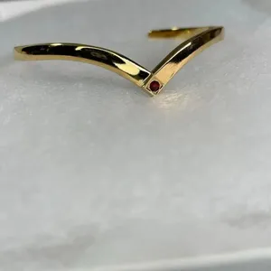 Avon gold tone V shaped cuff bracelet with faux ruby or garnet. Large thumbnail 3