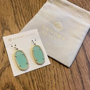 Kendra Scott earrings with light clear‎ turquoise oval stones and gold detailing thumbnail 2