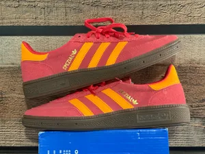 Adidas handball poles in a pretty red with light orange stripes thumbnail 1