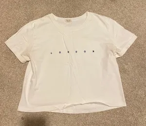 Brandy Melville “London” White Baby Tee thumbnail 1