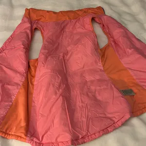 a Tangerine women's puffer vest in pink with orange side panels. Size large thumbnail 8