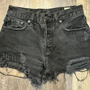 Vintage We The‎ Free Black denim shorts with frayed hem and distressing thumbnail 1