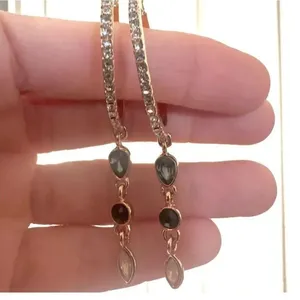 Gold tone hoop earrings with dangling rhinestones thumbnail 1