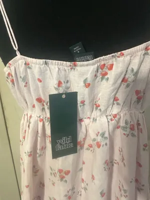 New with tags Wild Fable mini dress is a size small. This pink garment has a red strawberry print throughout. It is made of a linen-blend fabric and has adjustable spaghetti straps, a ruffled V-neckline with a tie-front detail, and a tiered skirt. thumbnail 3