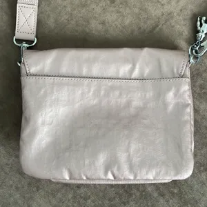 Kipling crossbody purse. Adjustable strap. Flap over closure w/ snap. Light pink thumbnail 5