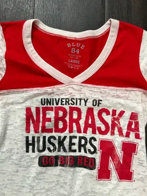Blue 84 women’s short-sleeve tee. Bold "Nebraska Huskers" graphics with team N logo. Red yoke and sleeve accents with white body. Lightweight and fan-ready for game day. Size large thumbnail 2