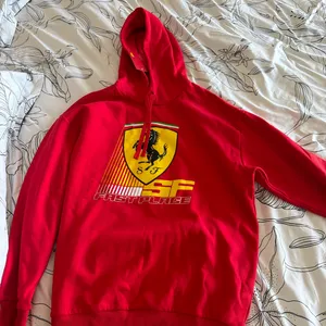 Red Ferrari hoodie with yellow shield logo featuring black horse and 'SF' text #racing #automotive thumbnail 1