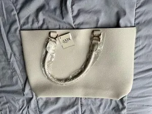 Ulta Beauty Tote Bag – Cream (New in packaging) Add a clean, elegant touch to your outfits with this beautiful tote! It comes in a super versatile cream/ivory shade, featuring a textured faux-leather finish and unique braided handles that give it a chic look. thumbnail 1