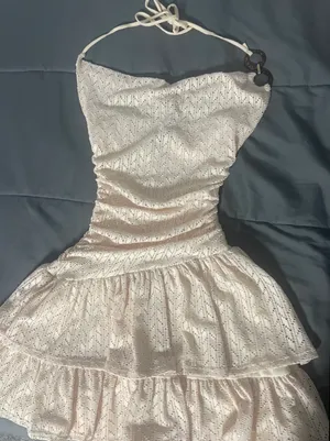 light-colored, halter-neck mini dress with a ruched waist and tiered ruffled skirt. thumbnail 1