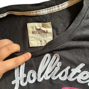 Y2K Hollister Co. black t-shirt with white 'Hollister' text and pink logo thumbnail 2