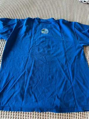 Comfortable blue short-sleeve shirt with white centered text that reads "It's amazing what a dollar can do." Soft, breathable cotton blend for everyday wear. Crew neckline and relaxed fit for easy styling. Blue color adds a bold pop to casual outfits. thumbnail 3
