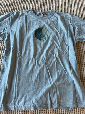 Soft light blue t-shirt. Small circular graphic at chest with teal and navy accents. Casual crew neck style. Easy staple for everyday wear. thumbnail 1