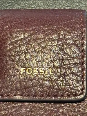 Fossil pebbled leather tab clutch wallet in a deep burgundy or berry color thumbnail 2