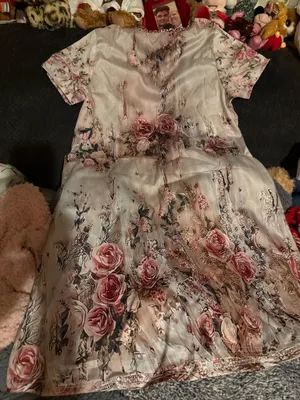 Elegant blush pink floral maxi dress with a V-neck and soft flowing fabric. Features romantic rose print and subtle lace-trim detail at the neckline. Lightweight and feminine for day or evening wear. Blush pink color complements neutral accessories. thumbnail 1