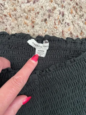 Black smocked crop top featuring dramatic puff sleeves with textured embroidery. Square neckline and fitted bodice create a flattering silhouette. Easy to style for casual or dressed-up looks. American Eagle size medium thumbnail 5