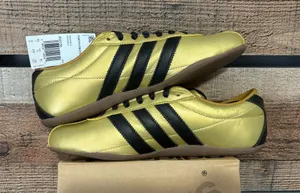 Gold adidas unisex sneakers. Metallic gold with black stripes thumbnail 1