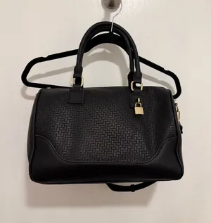 black woven duffle bag with gold hardware, some wear in the handles, no brand. thumbnail 1