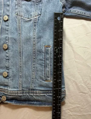 The Old Navy Blue Denim Trucker Jacket is a classic button-up long sleeve jacket in a traditional trucker style. Made from denim, manufactured in Bangladesh.Pit to pit: 18 in. Length: 20 in. Pre-owned with no visible wear. Buttons are all intact and the jacket lays flat with no distortion thumbnail 8