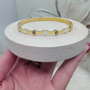 This chic bracelet showcases a beautiful gold finish with delicate white heart d thumbnail 7