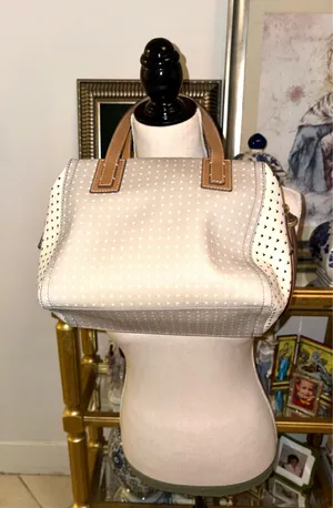 The Fossil Emma Satchel bag in white and gray with a polka dot print and brown leather handles stands out for its classic key charm. thumbnail 3