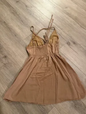 Wild Fable Tan Pom-Pom Trim Mini Dress - Size XS Get ready for sun-drenched days with this adorable Wild Fable mini dress. Featuring a neutral tan hue, this piece stands out with its delicate pom-pom trim along the neckline and a boho-inspired lace-up front with tassel details. The smocked waist ensures a flattering, flexible fit, while the lightweight fabric makes it perfect for beach trips or brunch. • Condition: Like new / Excellent • Size: Women’s XS • Style: Halter neckline with adjustable spaghetti straps • Color: Tan/Beige Smoke-free home. Fast shipping! thumbnail 2