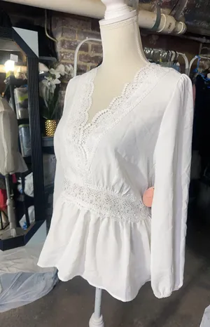 LOS ANGELES white lace V-neck long sleeve shirt top peplum tie cuff New with tag Smoke and pets free Same day shipping Elevate your wardrobe with this stunning white lace blouse from . The V-neckline and long sleeves add a touch of elegance to this top, while the peplum and tie cuff details create a flattering silhouette. The angel character and rose theme make it perfect for any occasion, from casual outings to formal events. Crafted from high-quality lace fabric, this blouse features adjustable features and is available in size S. The solid pattern and delicate lace accents make it a versatile piece that can be paired with any bottom. Whether you're dressing up or down, this Rose & Grey blouse is sure to turn heads. thumbnail 2