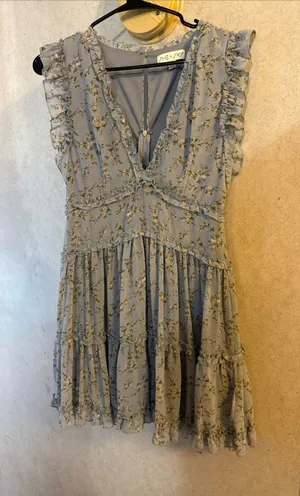 This is a light blue floral mini dress by She+Sky featuring a deep V-neckline and a tiered ruffled hem. thumbnail 1