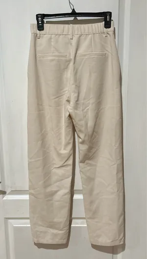 Abercrombie & Fitch high-waisted trousers. The design features a classic straight-leg silhouette with subtle front pleating, diagonal side pockets, and a button-and-zip fly closure in a cream or "oyster" shade. thumbnail 2