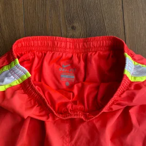 Nike Women’s Dri-FIT Tempo Running Shorts XS Bright Orange/Pink Neon Trim thumbnail 2