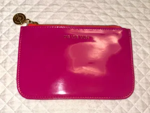 Small fuchsia pink patent leather makeup bag from Bath & Body Works with a gold metallic medallion pull. thumbnail 1