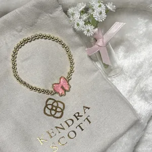 Kendra Scott Haley Bow Gold Stretch Bracelet featuring a custom-carved pink bow thumbnail 2