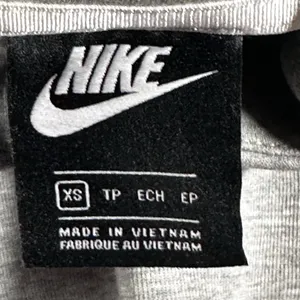 Nike Gray Minimalist Hoodie XS Y2K Athleisure Streetwear Description: Soft gray Nike hoodie with embroidered logo and kangaroo pocket. Perfect minimalist, gorpcore, streetwear, gym, and casual layering essential. Pre-owned Condition: Excellent Flaws: No significant flaws observed. Stored: Model created by AI. NikeHoodie Streetwear Athleisure MinimalistStyle Gorpcore HeatherGray Pullover LogoHoodie Layering Y2K thumbnail 4