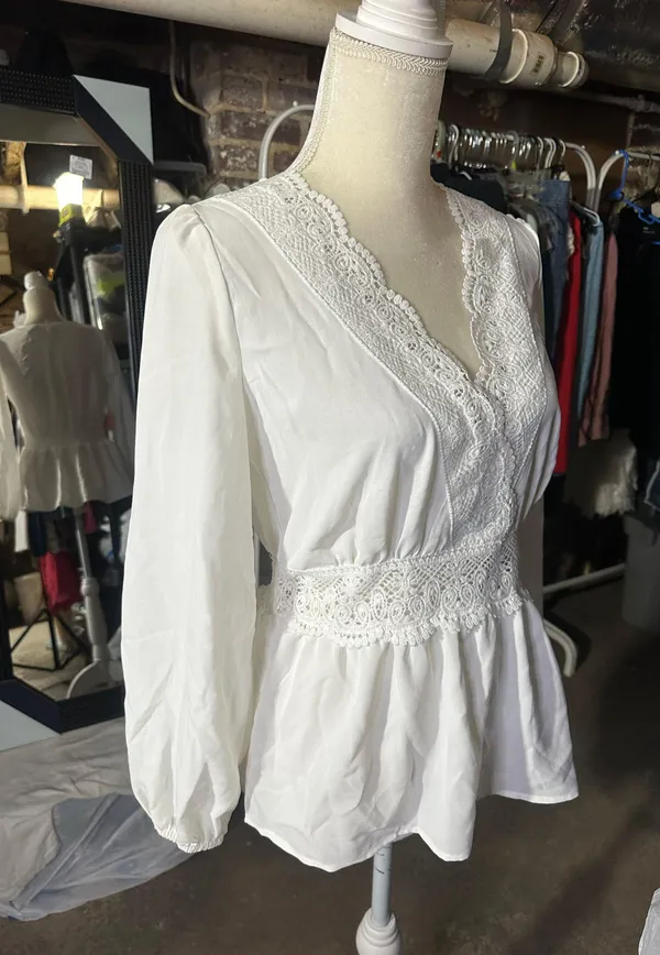 LOS ANGELES white lace V-neck long sleeve shirt top peplum tie cuff New with tag Smoke and pets free Same day shipping Elevate your wardrobe with this stunning white lace blouse from . The V-neckline and long sleeves add a touch of elegance to this top, while the peplum and tie cuff details create a flattering silhouette. The angel character and rose theme make it perfect for any occasion, from casual outings to formal events. Crafted from high-quality lace fabric, this blouse features adjustable features and is available in size S. The solid pattern and delicate lace accents make it a versatile piece that can be paired with any bottom. Whether you're dressing up or down, this Rose & Grey blouse is sure to turn heads. - Image 5