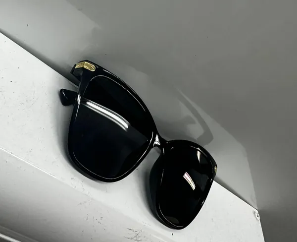 Stylish black sunglasses with gold accents. - Image 3