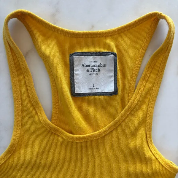 Y2K aesthetic with this classic vintage Abercrombie & Fitch tank top. This piece features a vibrant marigold yellow hue in a flattering, stretchy ribbed knit that's perfect for layering or wearing solo. - Image 2