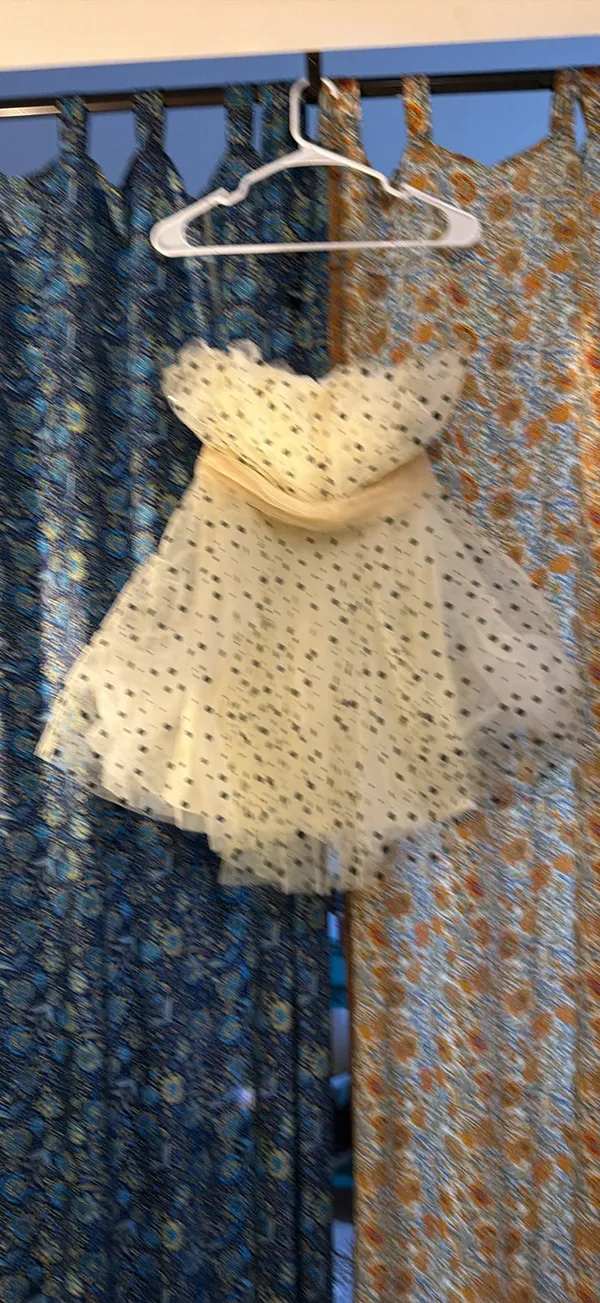 strapless tulle mini dress featuring a cream or light beige mesh fabric adorned with classic black polka dots. It is designed with a heavily ruched, pleated sweetheart bodice, a defined cinched waistband, and a voluminous tiered ruffled skirt. - Image 4