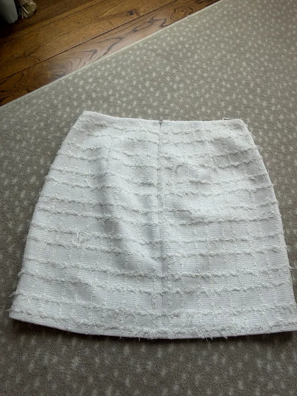 Chic white mini skirt with textured horizontal detailing. Slim, flattering silhouette. Easy to pair with tops or jackets for polished looks. - Image 2