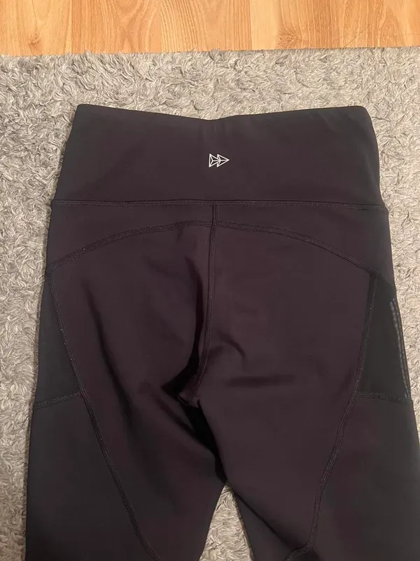 Black stretchy Yvette leggings with mesh design on outer thighs and ankles #activewear No flaws The lighting makes it look a little brown but they are plain black leggings I am a 26 in waist and 5'6" for reference - Image 3