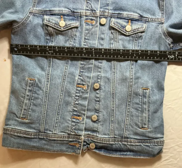 The Old Navy Blue Denim Trucker Jacket is a classic button-up long sleeve jacket in a traditional trucker style. Made from denim, manufactured in Bangladesh.Pit to pit: 18 in. Length: 20 in. Pre-owned with no visible wear. Buttons are all intact and the jacket lays flat with no distortion - Image 4