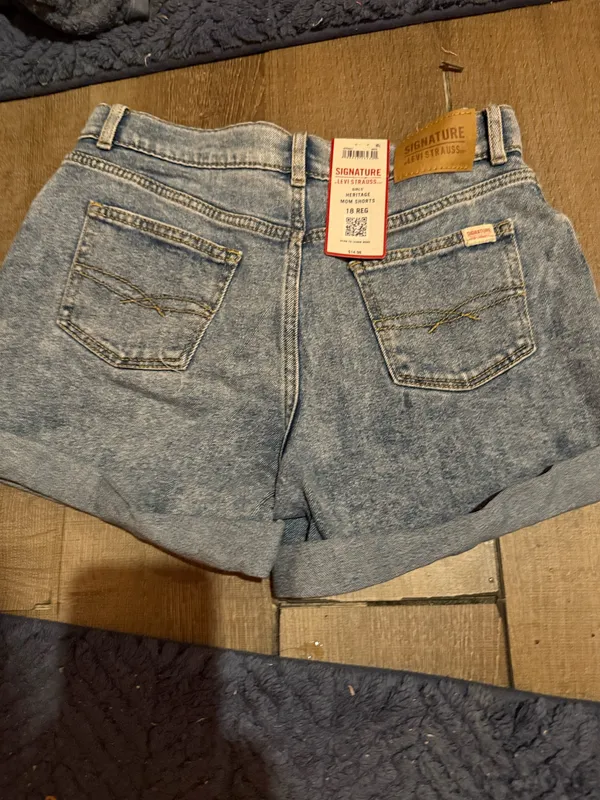 Signature Levi Strauss light blue denim shorts with delicate floral embroidery. Comfortable high-rise fit designed for everyday wear. Soft, faded blue wash that pairs easily with casual tops. Floral detailing adds a feminine touch. - Image 3