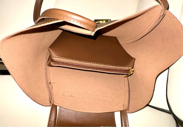 This brown bag features a minimalist design with gold details and a spacious structure. Made from 100% polyurethane, it has a magnetic closure with a gold-tone latch. Designed as a tote or shoulder bag, it's versatile for everyday use or travel. - Image 4
