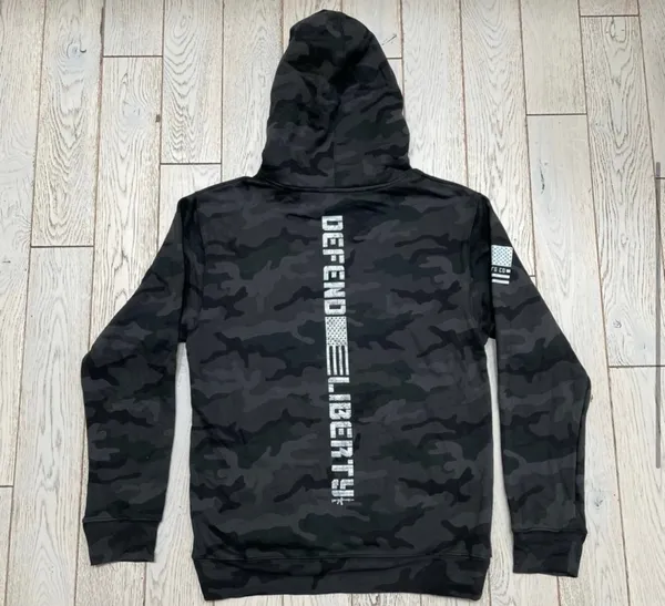 Howitzer "Defend Liberty" Black Camo Hoodie Elevate your casual wear with this rugged and patriotic Howitzer "Defend Liberty" Hoodie. Featuring a stealthy black multicam (camo) pattern, this hoodie is designed for those who value both style and a strong message of freedom. Constructed with high-quality, durable fabric, it offers a comfortable fit perfect for outdoor adventures, range days, or daily wear. Product Features: • Brand: Howitzer Manufacturing Co. • Design: Bold "DEFEND LIBERTY" distressed graphic with the American flag and an AR-15 silhouette on the front. • Back Detail: A vertical "DEFEND LIBERTY" spine graphic for a unique look from every angle. • Sleeve Detail: Features the Howitzer brand American flag patch on the sleeve. • Pattern: Modern black/dark grey camouflage. • Style: Pullover with adjustable drawstring hood and a spacious kangaroo front pocket. - Image 7