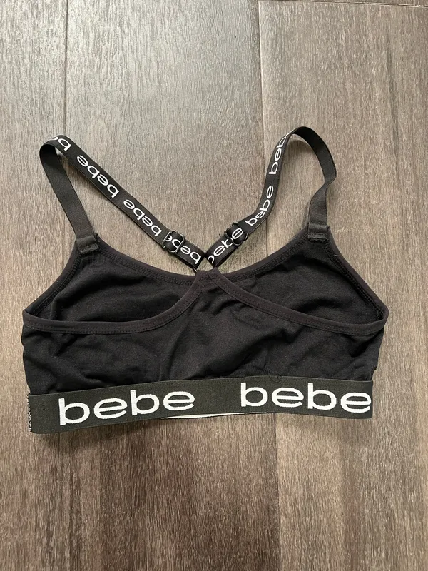 Sleek black bralette featuring bold bebe logo on elastic band. Stretch fabric for light support and comfort. Thin adjustable logo straps with a stylish crisscross back. Clean, minimalist look ideal for layering. Bebe size small - Image 3