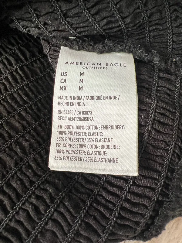 Black smocked crop top featuring dramatic puff sleeves with textured embroidery. Square neckline and fitted bodice create a flattering silhouette. Easy to style for casual or dressed-up looks. American Eagle size medium - Image 3