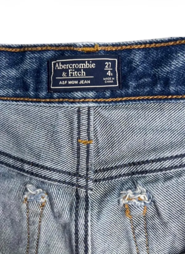 Abercrombie & Fitch Mom Cutoff High Rise Denim Shorts Womens 27 Abercrombie & Fitch high rise cutoff mom shorts in a distressed medium wash. Raw frayed hemline with classic 5 pocket styling and zip fly button closure. Modern release design features a clean back waist without traditional leather logo patch. Rigid 100 percent cotton denim build with structured vintage silhouette. Excellent preowned. No flaws, stains, or unintentional tears. Measurements Flat Lay: Waist 14.25 in Rise 10 in Inseam 2 in Hips 17 in - Image 4