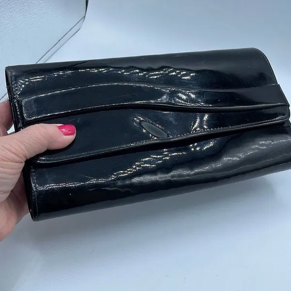 Black faux patent leather clutch with wave design on front. - Image 2