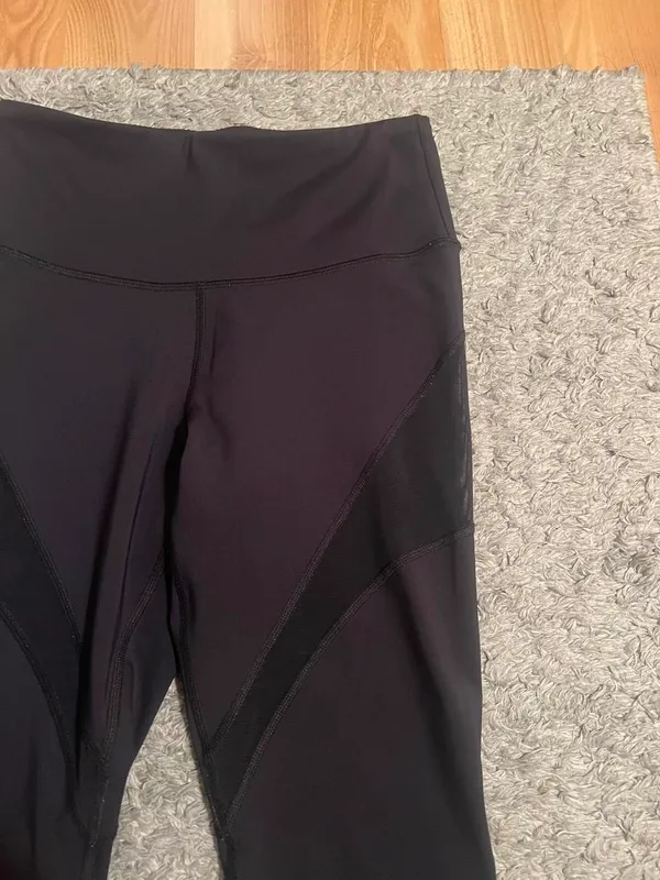 Black stretchy Yvette leggings with mesh design on outer thighs and ankles #activewear No flaws The lighting makes it look a little brown but they are plain black leggings I am a 26 in waist and 5'6" for reference - Image 2